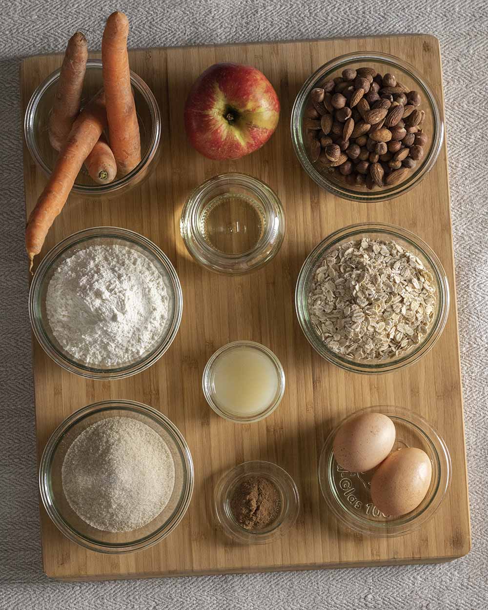Die Zutaten für unsere saftigen Möhren-Muffins: Möhren, Apfel, Nüsse, Öl, Mehl, Haferflocken, Zitrone, Zucker, Zimt und Eier