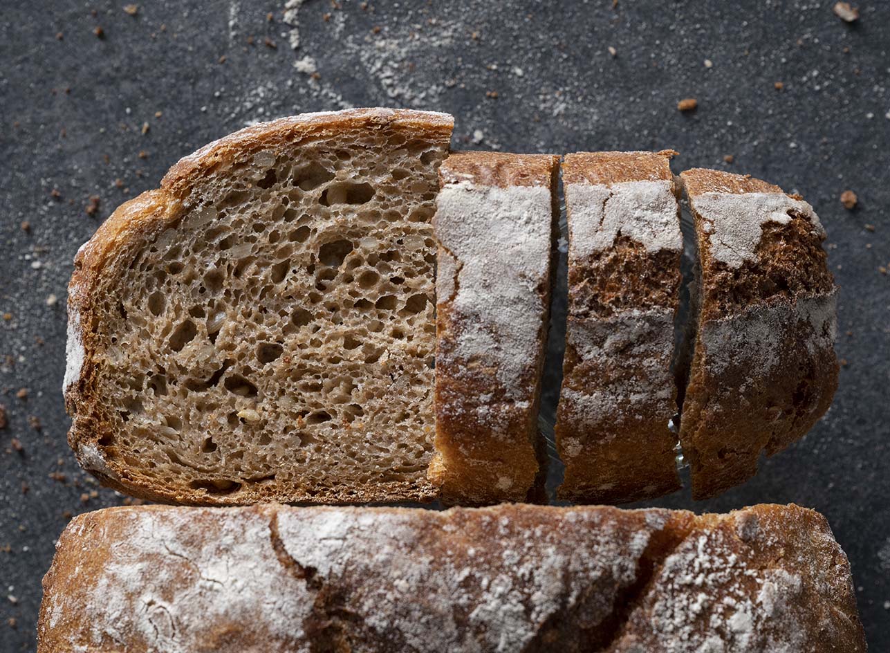 Nahaufnahme einer Brotscheibe, die die lockere Porung unseres Brotes zeigt, das wir im Topf gebacken haben.