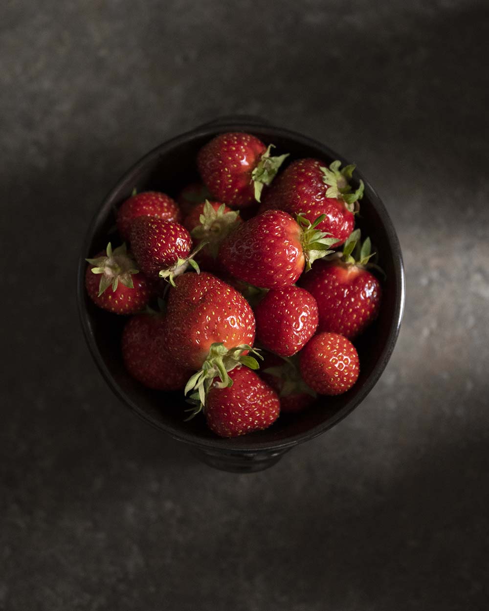 Eine Schale mit frischen saisonalen Erdbeeren, die wir von einem regionalen Hof beziehen.