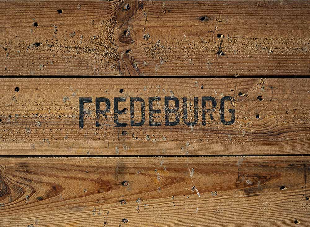 Eine Holzkiste, in denen Gemüse gelagert wird. In das Holz ist der Name Domäne Fredeburg eingebrannt.