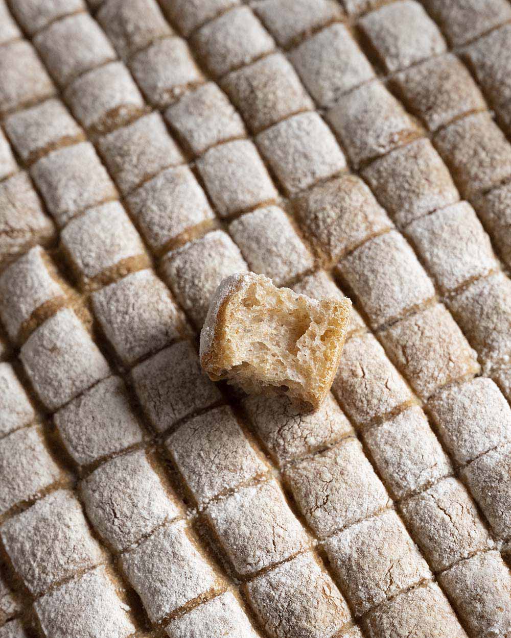Unser Fondue-Brot ist fertig gebacke. Die Aufnahme zeigt einen einzelnen Würfel, den wir abgebrochen und auf die ganze Oberflüche des Brots gelegt haben.