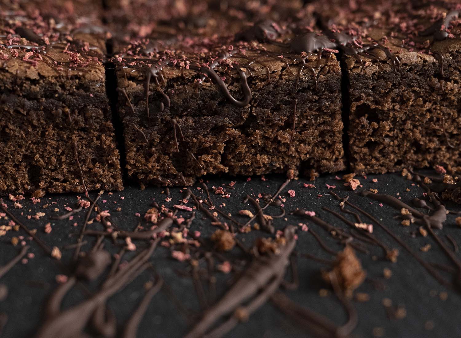 Seitenansicht auf den Kuchen: Wir haben den ganzen Brownie in mehrere Stücke geschnitten und von der Seite fotografert, damit man das innere gut erkennt.